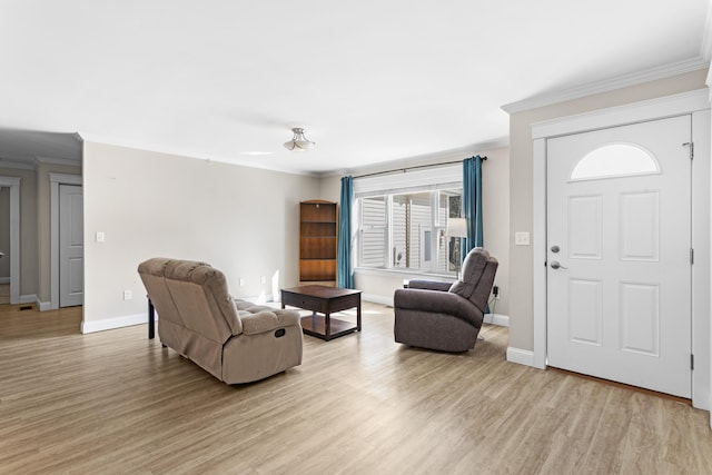 living area featuring light wood-style flooring, baseboards, and ornamental molding