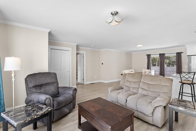 living area featuring light wood-style floors, baseboards, and ornamental molding