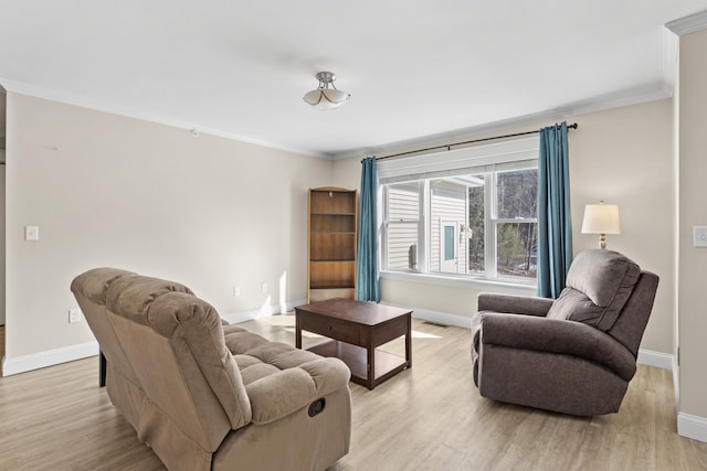 living area with crown molding, baseboards, and light wood finished floors