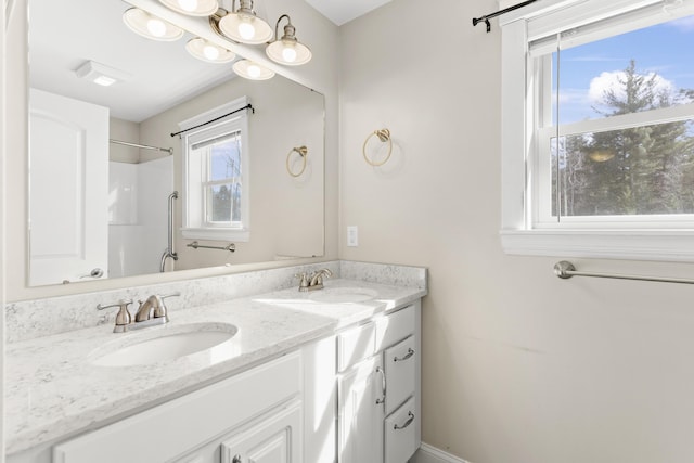 bathroom featuring double vanity, a shower, and a sink