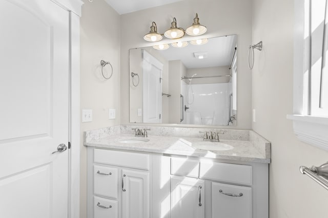 bathroom featuring a sink, a shower, and double vanity