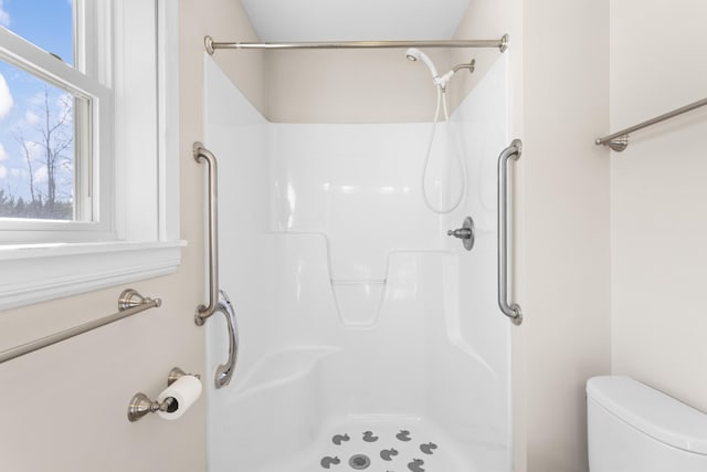 bathroom featuring a shower and toilet