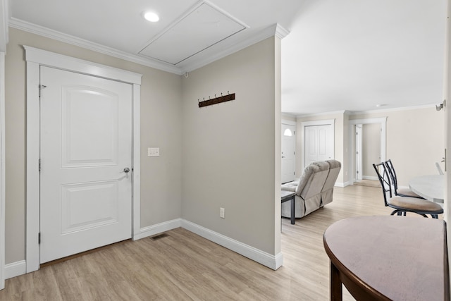 entrance foyer featuring crown molding, light wood-style flooring, visible vents, and baseboards