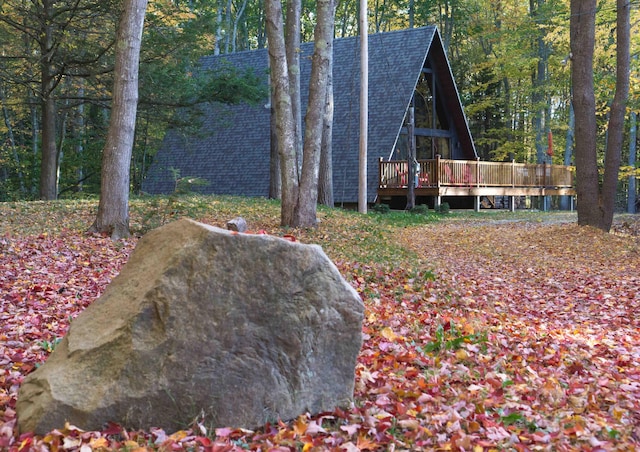 exterior space with a forest view and a wooden deck