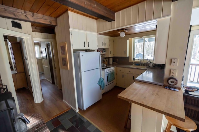 kitchen with wooden ceiling, white appliances, beam ceiling, and a sink