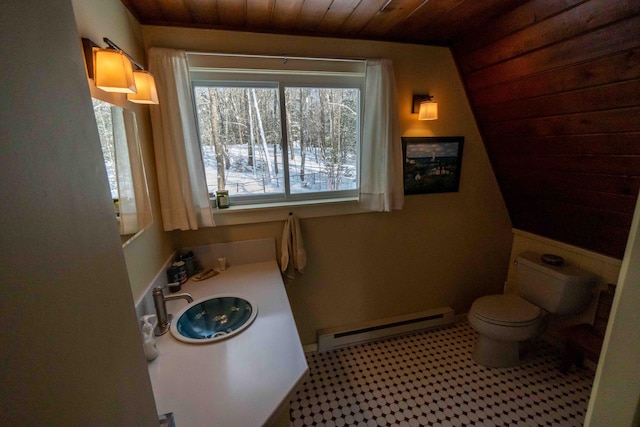 bathroom featuring a baseboard radiator, toilet, a sink, wood ceiling, and tile patterned floors