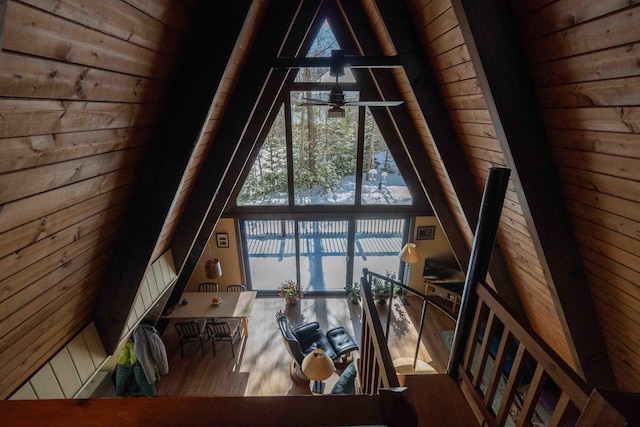 unfurnished living room featuring wood ceiling, wood finished floors, wood walls, high vaulted ceiling, and beam ceiling