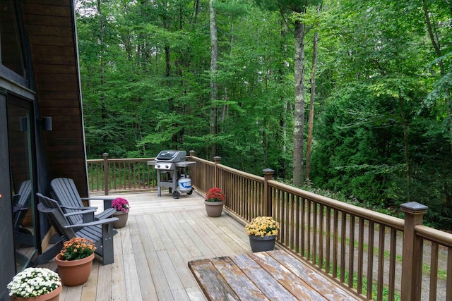 wooden deck featuring a wooded view and area for grilling