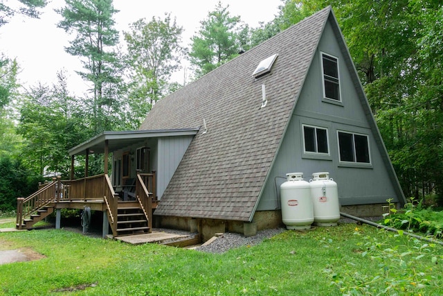 exterior space featuring stairs, roof with shingles, and a lawn