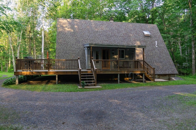 a-frame style home with a shingled roof and a chimney