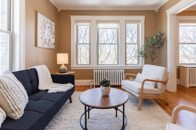 sitting room featuring baseboards, radiator heating unit, ornamental molding, and wood finished floors