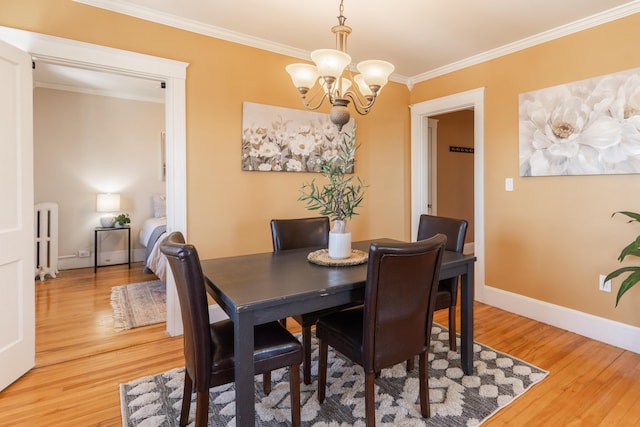 dining area featuring a notable chandelier, radiator, ornamental molding, light wood-style floors, and baseboards