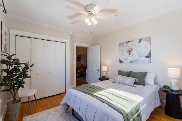 bedroom featuring crown molding, a closet, a ceiling fan, and light wood-style floors