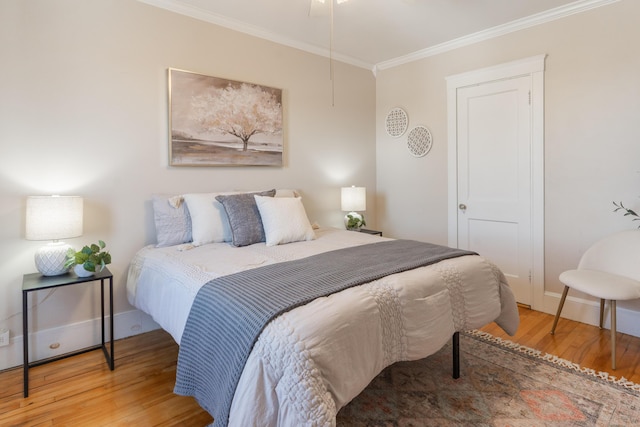 bedroom with baseboards, crown molding, and wood finished floors