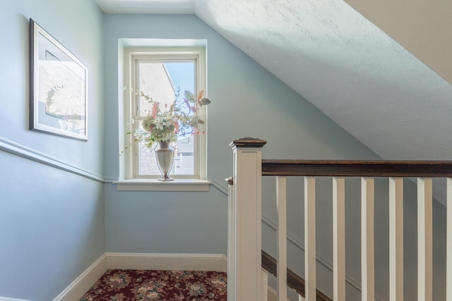 interior space with a healthy amount of sunlight, vaulted ceiling, and baseboards