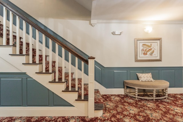 staircase featuring ornamental molding, a wainscoted wall, and a decorative wall