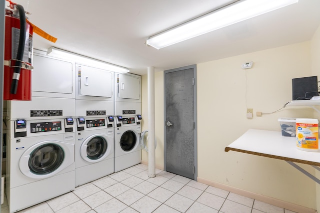 common laundry area with stacked washer / dryer, washing machine and clothes dryer, and light tile patterned floors