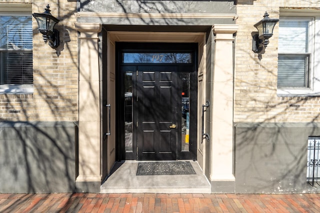 doorway to property featuring brick siding