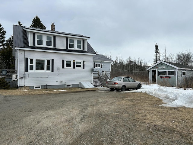 view of front facade featuring metal roof and a chimney