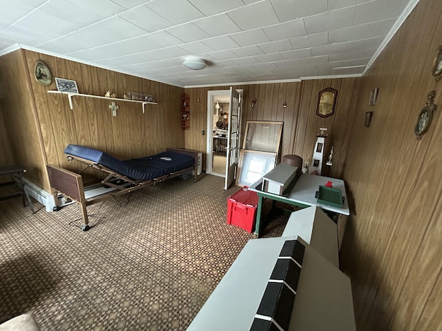 carpeted bedroom featuring wooden walls and ornamental molding