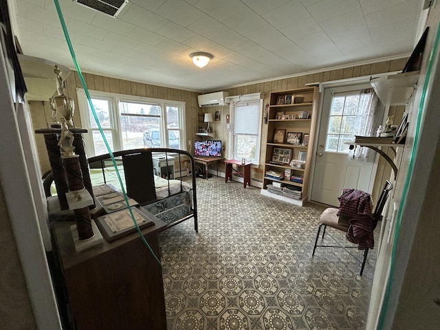 home office featuring a healthy amount of sunlight, crown molding, visible vents, and an AC wall unit