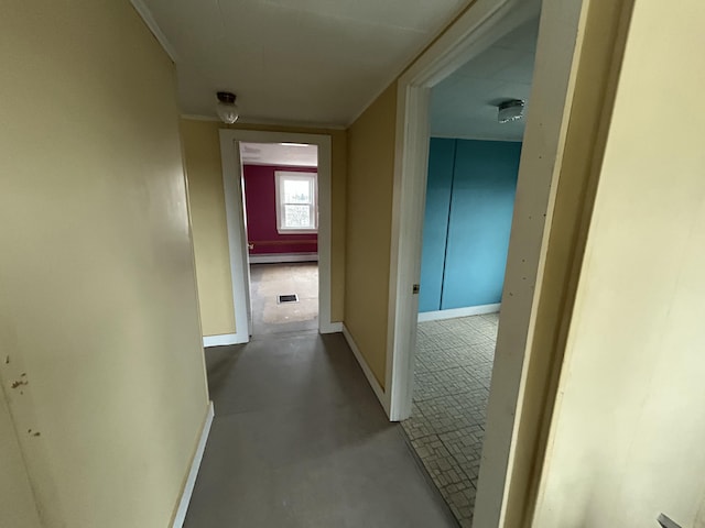 corridor featuring baseboards, visible vents, concrete floors, and baseboard heating