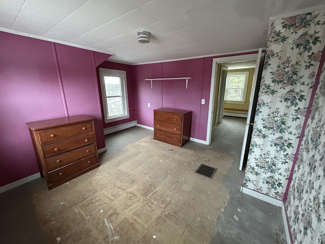 unfurnished bedroom with baseboard heating, visible vents, and baseboards