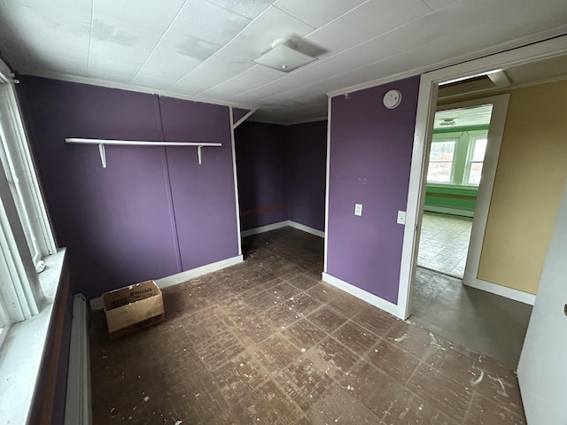 interior space featuring a baseboard radiator, baseboards, and tile patterned floors