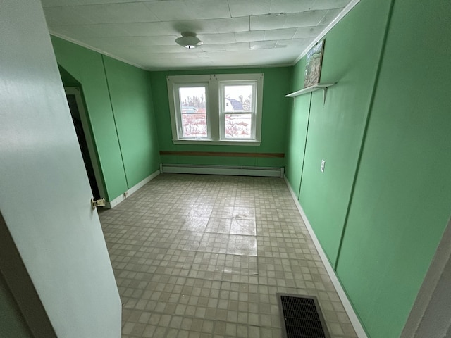 spare room featuring ornamental molding, a baseboard radiator, visible vents, and baseboards