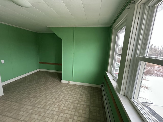 unfurnished room with ornamental molding, baseboards, and tile patterned floors