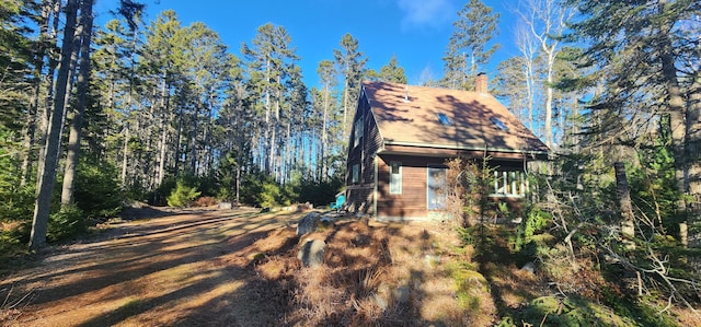 view of property exterior featuring a forest view