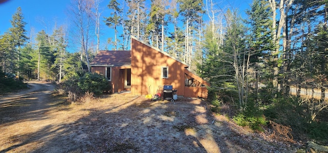 view of side of home featuring roof with shingles