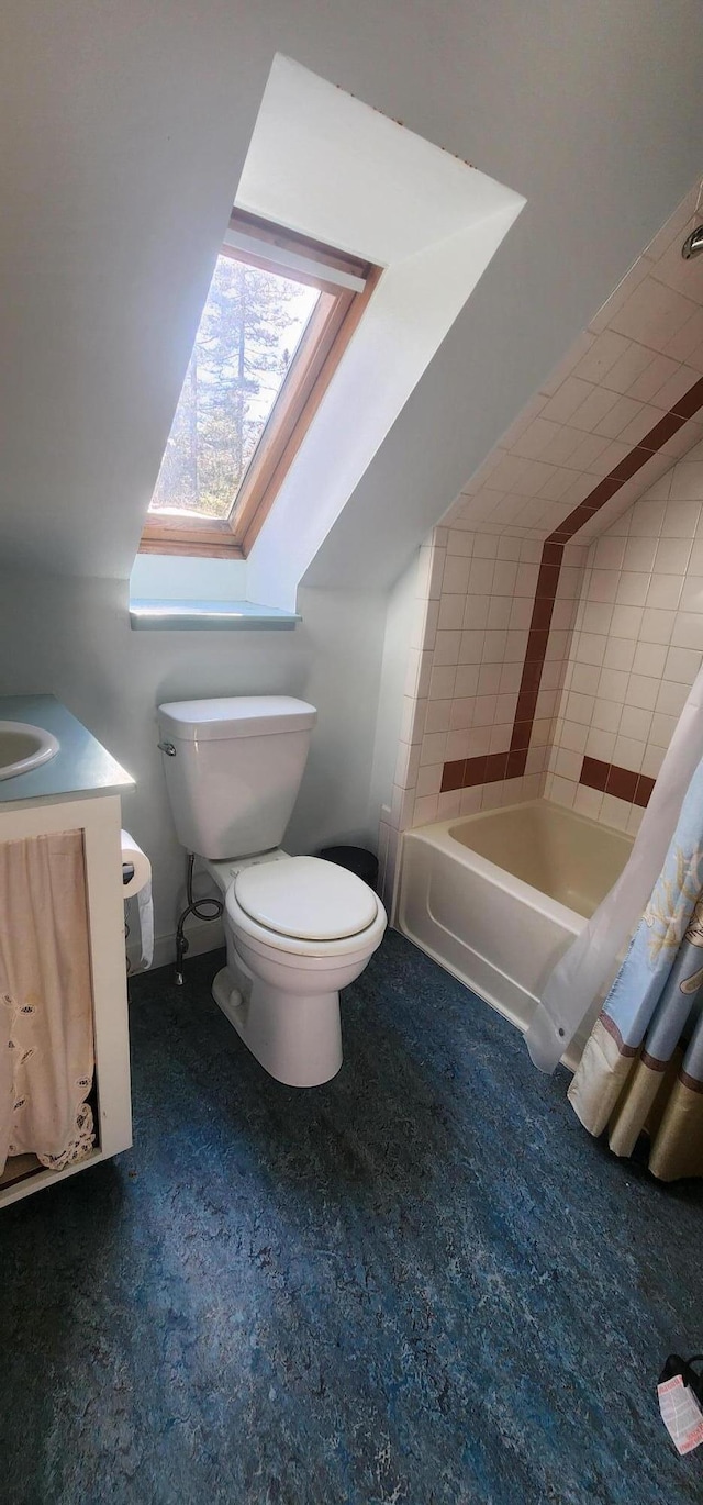 bathroom featuring lofted ceiling with skylight, vanity, and toilet