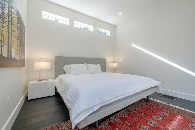 bedroom featuring multiple windows, baseboards, and dark wood finished floors