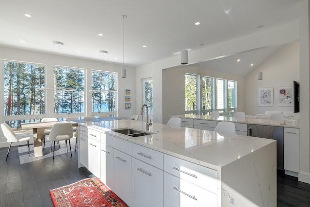 kitchen featuring a spacious island, a sink, dark wood finished floors, and pendant lighting