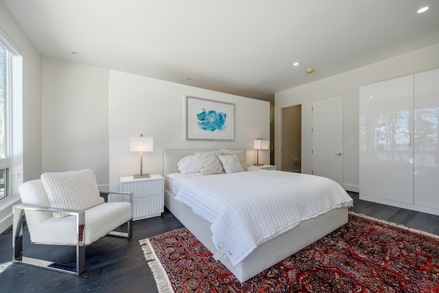 bedroom with dark wood finished floors and recessed lighting