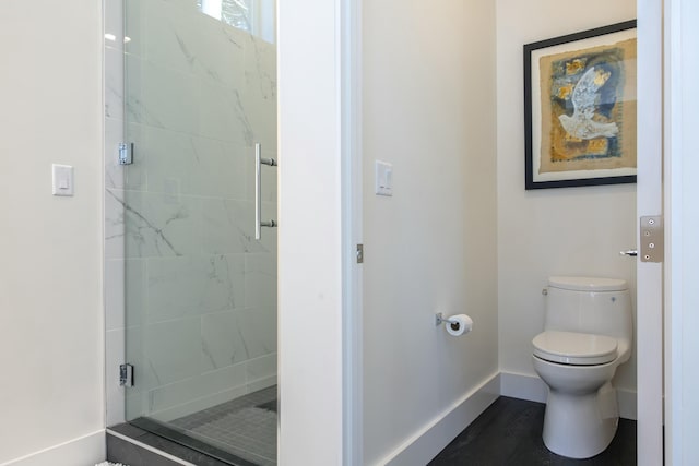 full bath featuring toilet, a shower stall, and baseboards