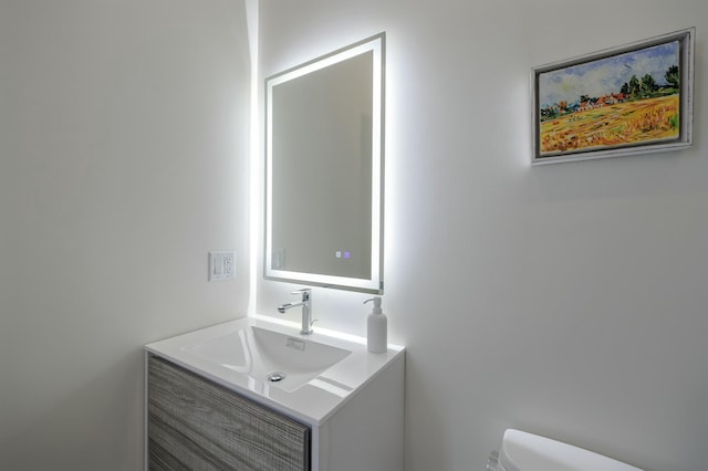 half bathroom with toilet and vanity