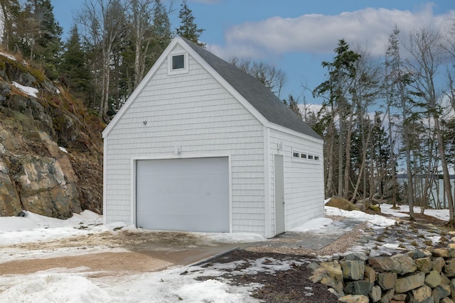 snow covered garage with a detached garage