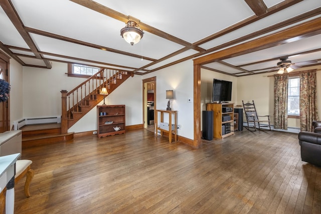 living area with plenty of natural light, wood-type flooring, stairway, and baseboard heating