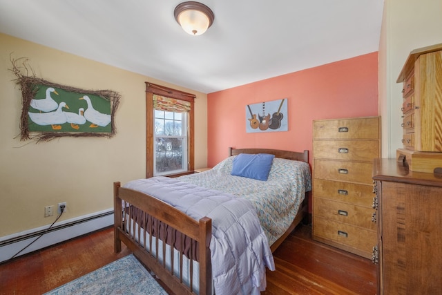 bedroom with a baseboard heating unit and wood finished floors