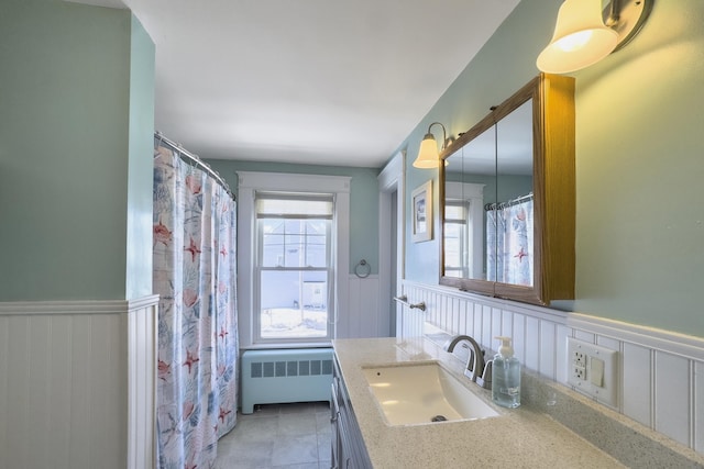 full bathroom with tile patterned flooring, wainscoting, vanity, and radiator heating unit