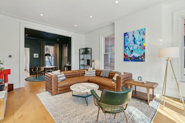 living room with recessed lighting, baseboards, radiator, light wood finished floors, and crown molding