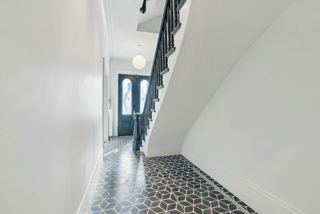 hallway featuring stairs, baseboards, and tile patterned floors