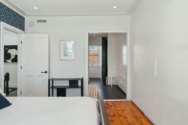 bedroom featuring ornamental molding, recessed lighting, visible vents, and wood finished floors