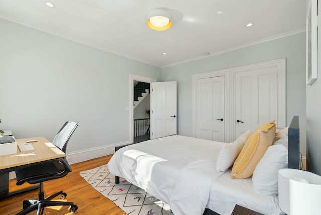 bedroom with recessed lighting, light wood-style flooring, baseboards, and ornamental molding