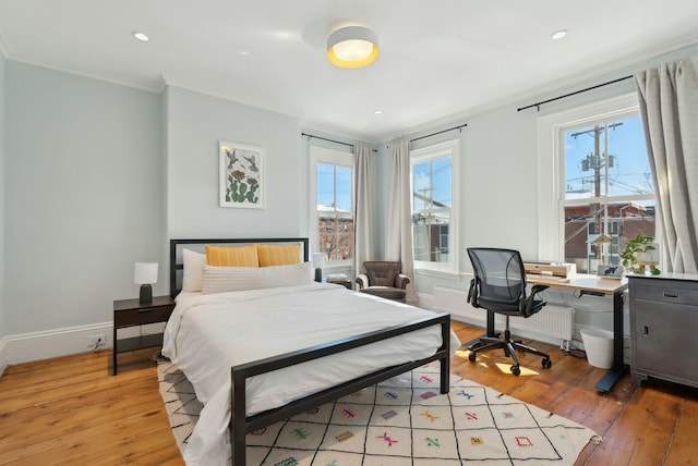 bedroom with light wood finished floors, baseboards, crown molding, and recessed lighting