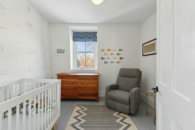 bedroom featuring a crib and baseboards