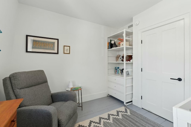 living area with visible vents and baseboards