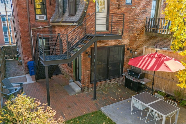 rear view of house featuring fence and brick siding